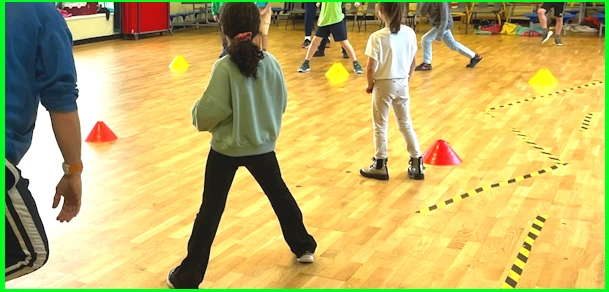 Participants in an inclusive sports work shop play with balls and cones
